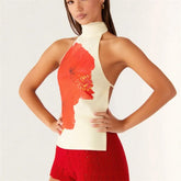 Woman wearing a white top with red floral design and red shorts